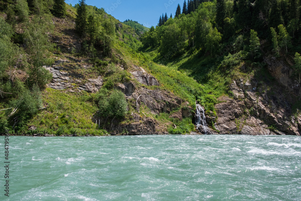 Blue mountain river with small waterfall influent to it. Koksu river in Dzungarian Alatau. Blue mountain river with small waterfall influent to it. Koksu river in Dzungarian Alatau.