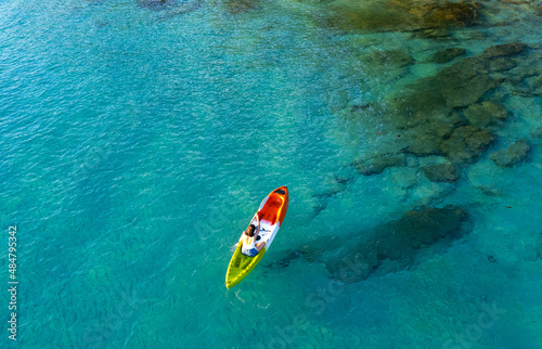 Aerial view of a kayak in the blue sea .Woman kayaking She does water sports activities. © Photo Sesaon