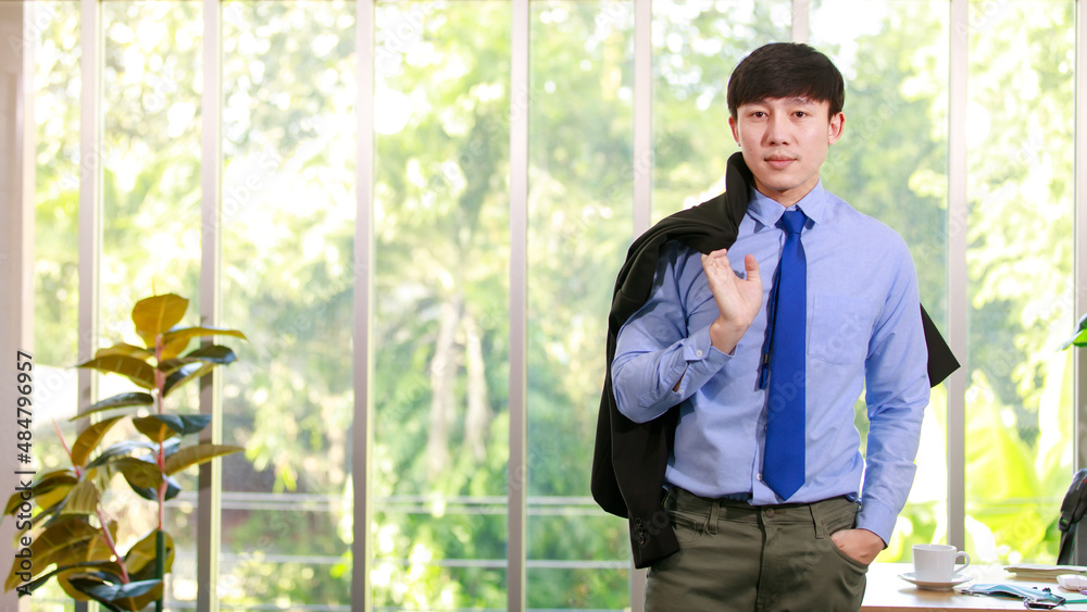 Smart young executive businessman on formal working suit and elegant neck tie standing confidently at company office and carrying jacket ready to enjoy lifestyle of corporate management Smart young executive businessman on formal working suit and elegant neck tie standing confidently at company office and carrying jacket ready to enjoy lifestyle of corporate management