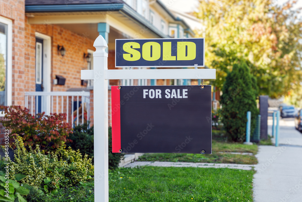 Naklejka premium Sold sign in front of a house in a residential neighborhood in summer. Copy space for text