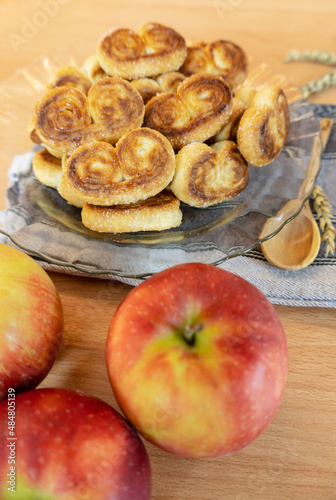 Palmiers cookies with sugar and apples on the table close-up, vertical
