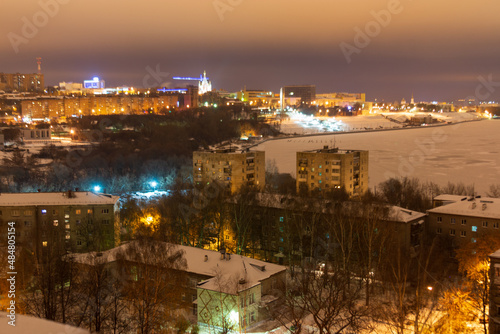 evening winter city, embankment with illumination, high-rise buildings