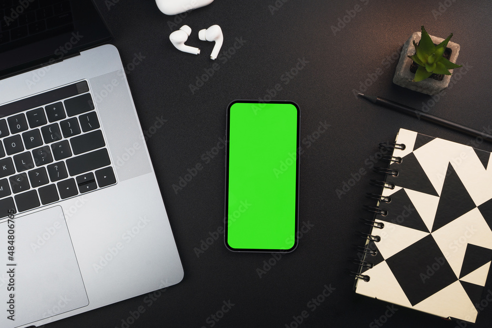 Smartphone with green screen on black background table. Office environment.  Chroma Key Stock Photo | Adobe Stock