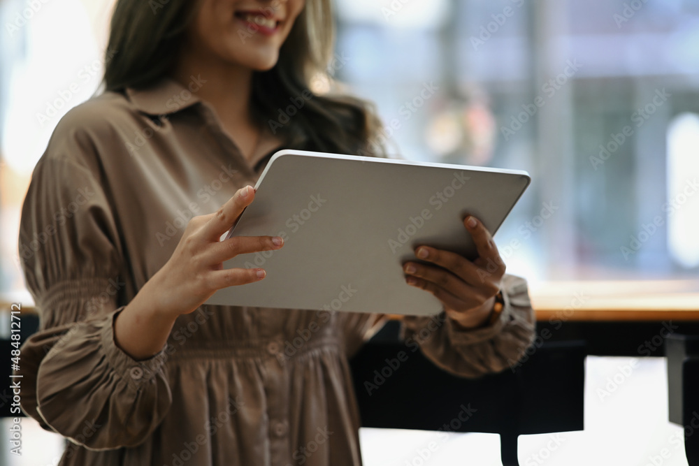 Creative woman standing in office and using digital tablet. Creative woman standing in office and using digital tablet.