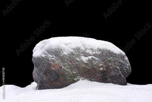 natural stone in snow isolated on black background photo