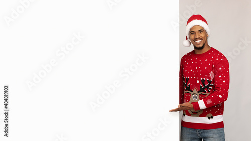 Cheerful african american guy standing by empty advertisig board, panorama photo