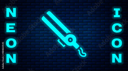 Glowing neon Curling iron for hair icon isolated on brick wall background. Hair straightener icon. Vector