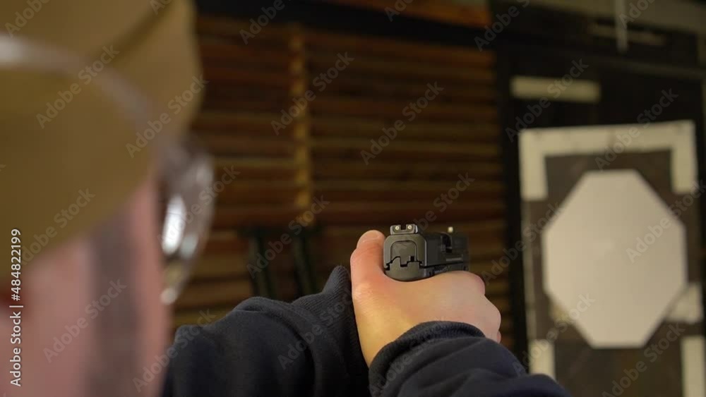 The shooter aims with a pistol, close-up, focus on the rear sight, the camera moves, soft focus The shooter aims with a pistol, close-up, focus on the rear sight, the camera moves, soft focus