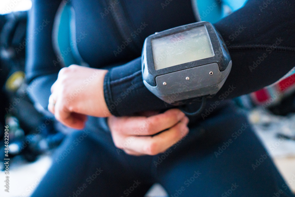 Woman adjusting her diving watch.