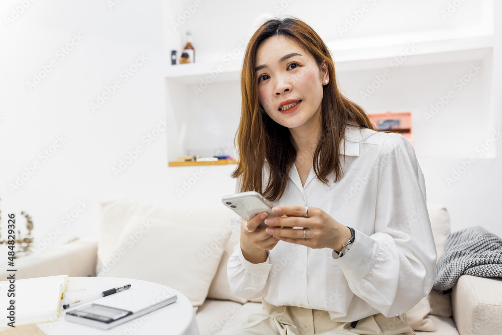 Startup small business, Young chinese woman Entrepreneur using smartphone or tablet taking receive and checking online purchase shopping order to preparing pack product box. online selling concept Startup small business, Young chinese woman Entrepreneur using smartphone or tablet taking receive and checking online purchase shopping order to preparing pack product box. online selling concept