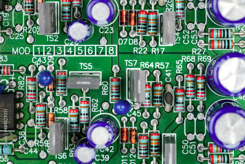 Closeup of a printed circuit board with components such as Resistors and integrated circuits. 