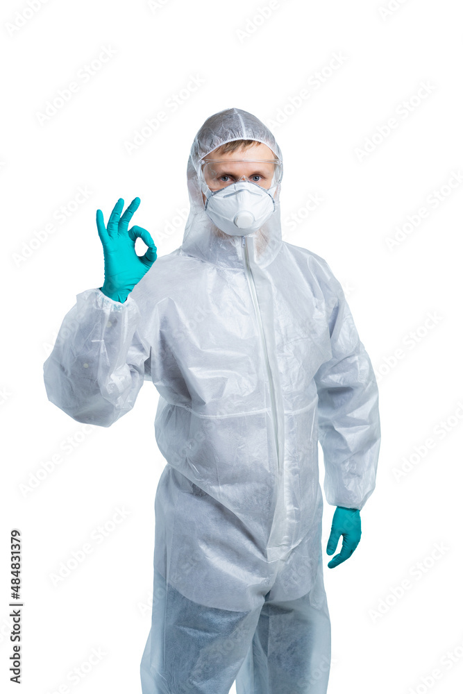 A man in special protective clothing shows the ok sign with his fingers. bacteria, viruses, toxic, corrosive substances. coronavirus. isolated A man in special protective clothing shows the ok sign with his fingers. bacteria, viruses, toxic, corrosive substances. coronavirus. isolated