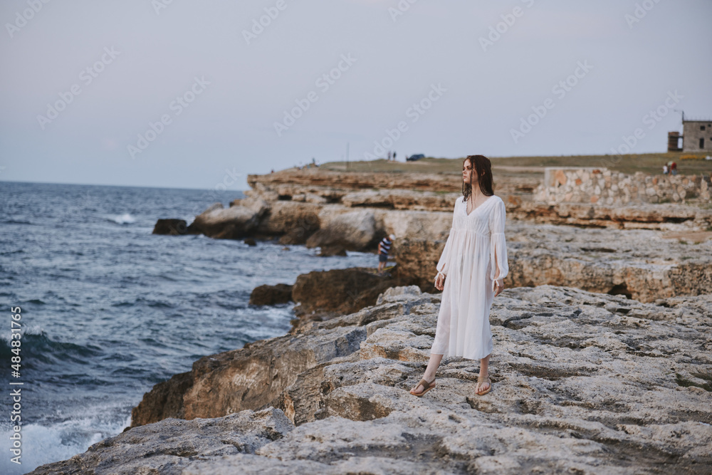 pretty woman in white dress stands on the stones beach nature freedom pretty woman in white dress stands on the stones beach nature freedom