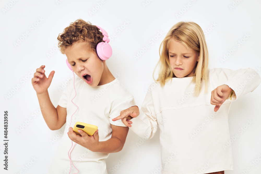 Two preschool children boy and girl headphones with phone entertainment lifestyle childhood Two preschool children boy and girl headphones with phone entertainment lifestyle childhood