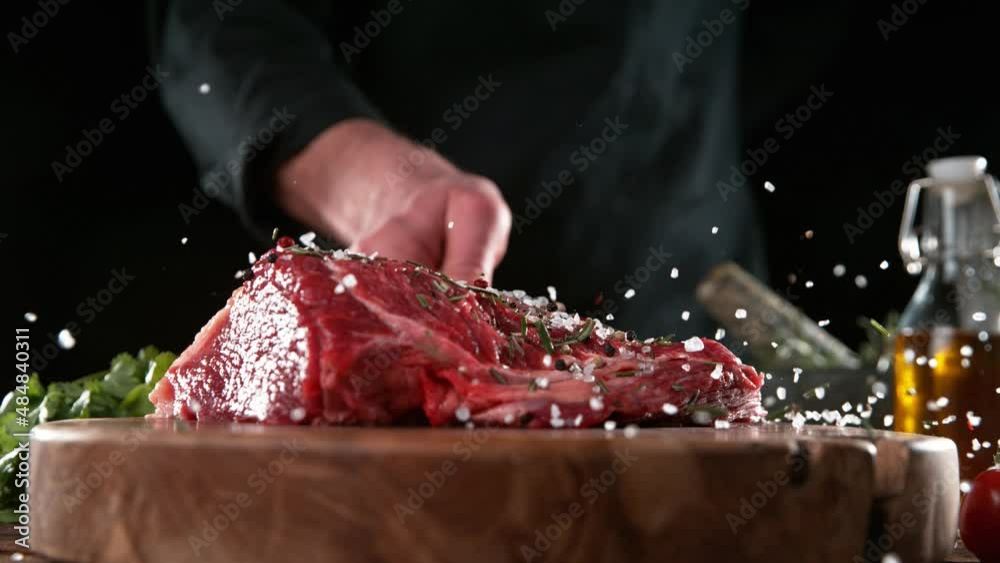 Close-up of falling tasty beef steak in kitchen, super slow motion, camera movement, filmed on high speed cinematic camera at 1000 fps.