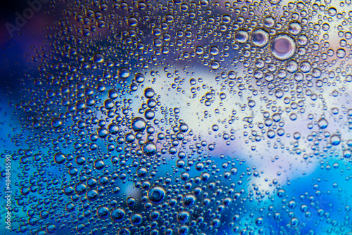 Bubbles in oil in water on blue and white colour abstract background.