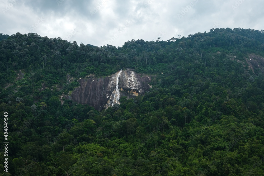 Background image of tropical mountain and Jelawang Waterfall in Gunung Stong National Park, Dabong, Kelantan, Malaysia.
