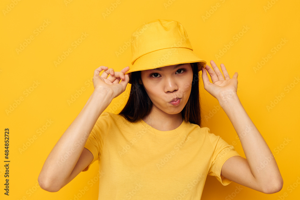 woman with Asian appearance wearing a yellow hat posing emotions isolated background unaltered woman with Asian appearance wearing a yellow hat posing emotions isolated background unaltered