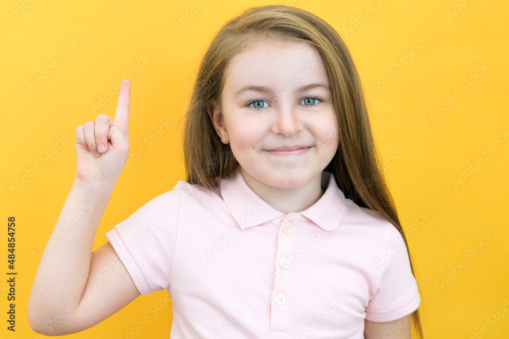 Wow, look, advertise here! Portrait of an astonished cute girl pointing at an empty space in the background, a preschooler shows a copy space for an advertisement. Wow, look, advertise here! Portrait of an astonished cute girl pointing at an empty space in the background, a preschooler shows a copy space for an advertisement.
