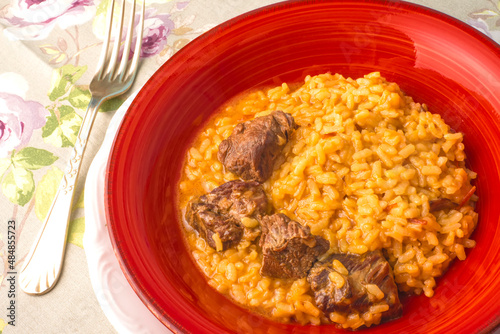 Italian beef risotto, rice with beef meat background.