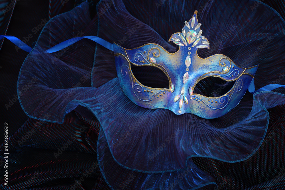 Photo of elegant and delicate Venetian mask over blue dark background - obrazy, fototapety, plakaty 