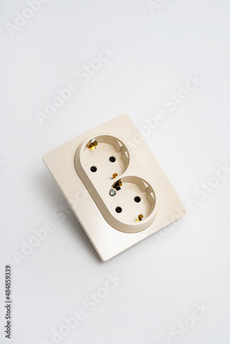 Double socket insulated on a white background. 2 sockets connected by one monolithic housing. The socket has two plug connectors, but is installed in one standard socket.