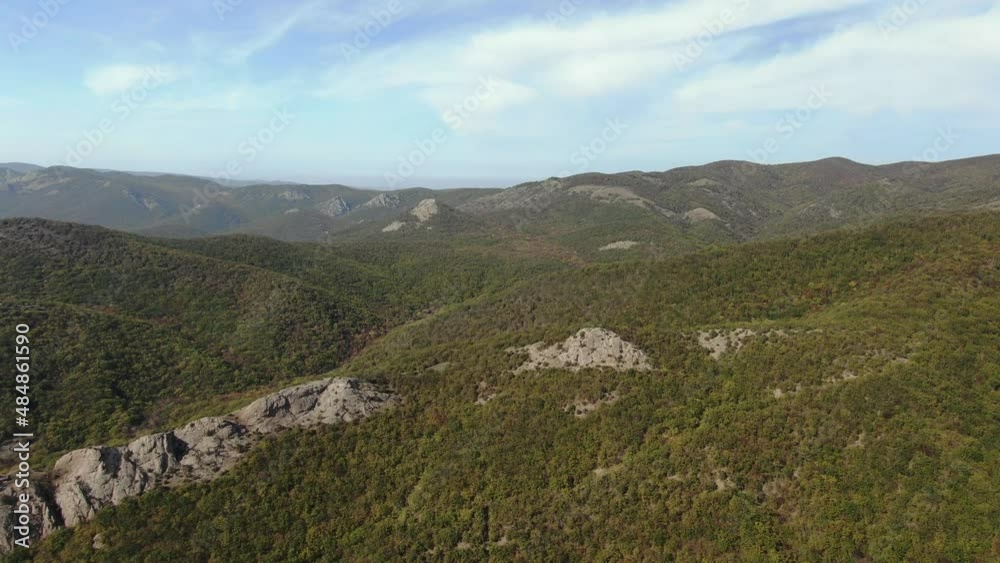 Flight over the mountain range whose slopes are overgrown with forest. Natural autumn background Flight over the mountain range whose slopes are overgrown with forest. Natural autumn background