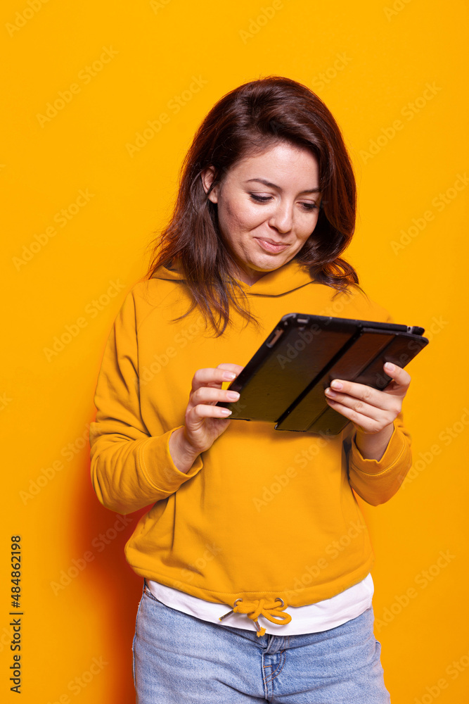 Modern woman using digital tablet with touch screen on camera. Cheerful person holding modern gadget and looking at display to work on online internet connection. adult with device Modern woman using digital tablet with touch screen on camera. Cheerful person holding modern gadget and looking at display to work on online internet connection. adult with device