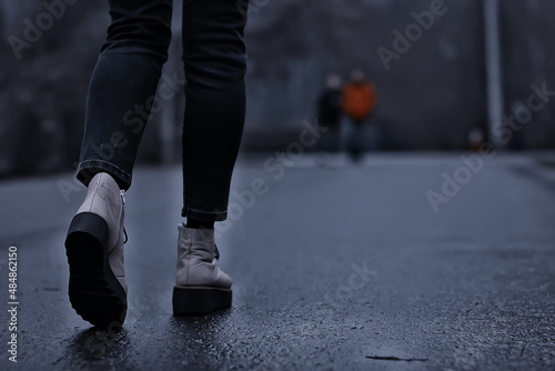 feet in winter boots walk in the park, abstract seasonal background, November weather