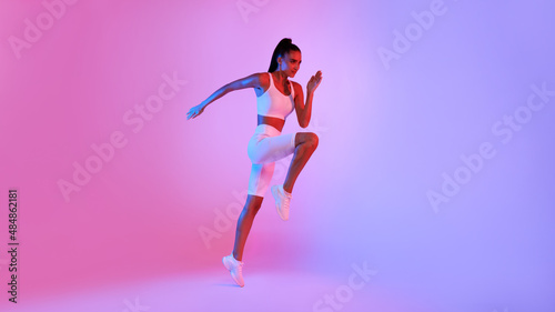 Sporty Woman Jumping Exercising Posing Over Neon Background, Panorama