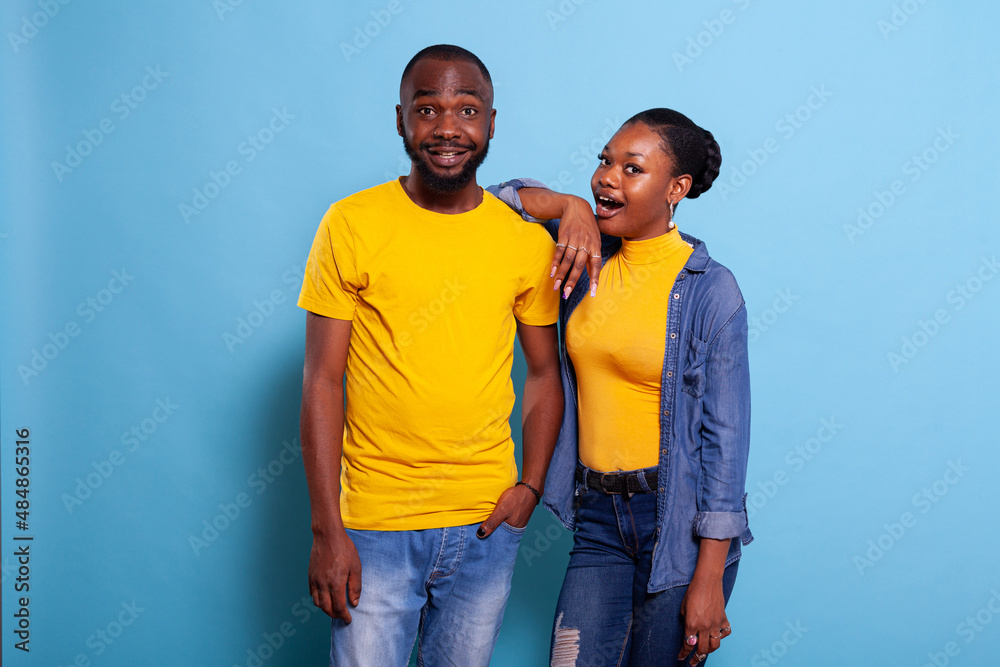 Astonished man and woman posing with mouth open in studio, having surprised facial expression. African american people in relationship being shocked after hearing unexpected news.