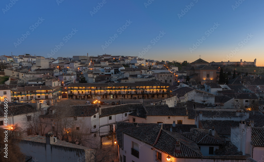 village of chinchon at sunset with orange colors and village lights on