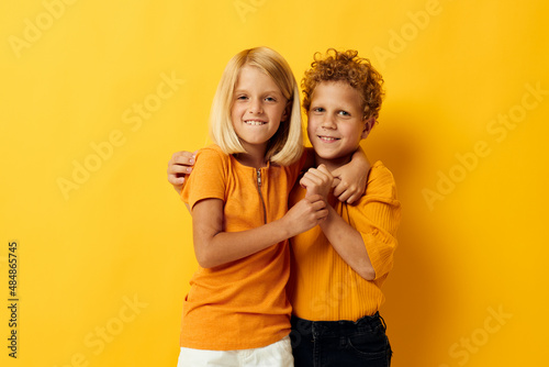 Cute preschool kids casual wear games fun together posing on colored background
