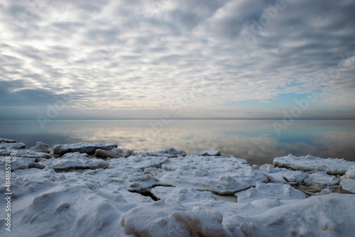Fototapeta Naklejka Na Ścianę i Meble -  Winter seascape, slow freezing sea, glorious skies, white pieces of ice by the sea