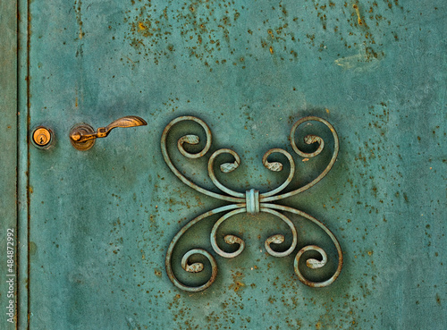 Fragment photo of door lock and decor detail; entrance door with decorative elements, sardiniain italian door 