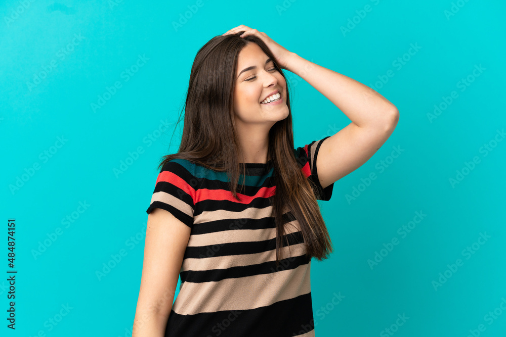 Teenager Brazilian girl over isolated blue background smiling a lot