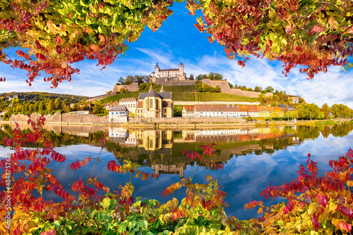 Wurzburg. Main river waterfront and scenic Wurzburg castle and vineyards reflection view through autumn leaves photo