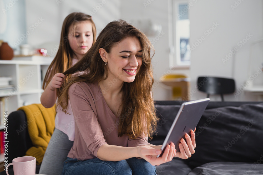 mother and daughter using digital tablet at home mother and daughter using digital tablet at home