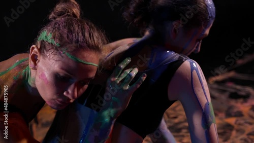 creative hobby of two dancer women, ladies are dancing and smearing paints over skin