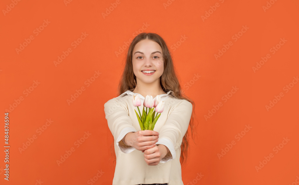 happy kid hold flowers for spring holiday. teen girl with bouquet on orange background. happy kid hold flowers for spring holiday. teen girl with bouquet on orange background.