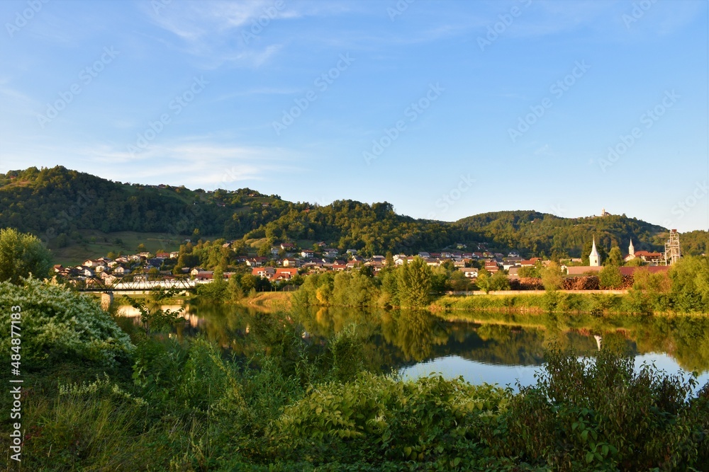 View of the town of Sevnica with Sava river in front and forest covered hill behind in Stajerska, Slovenia