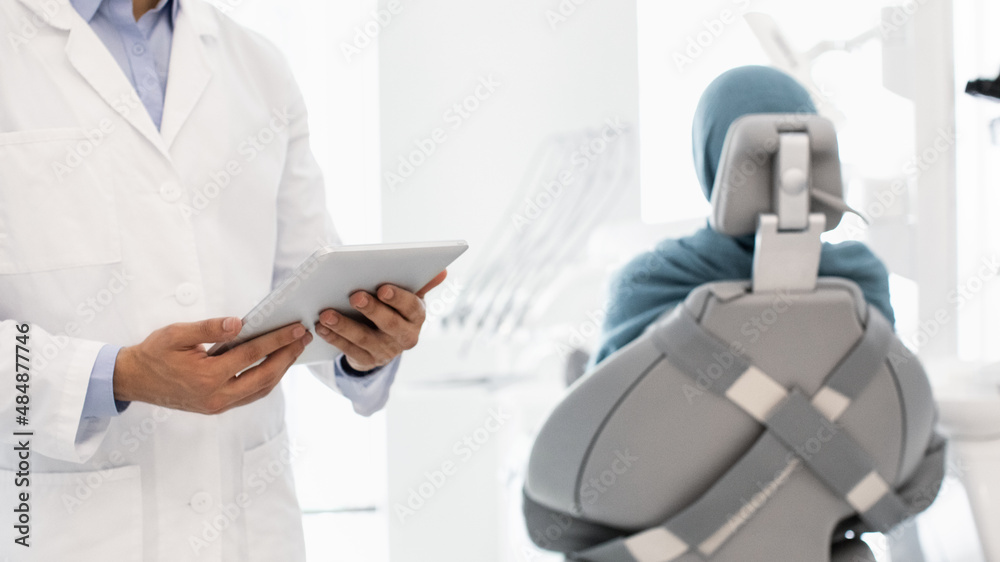 Technology And Healthcare. Dentist With Digital Tablet In Hands Standing In Cabinet