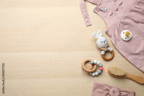 Cute baby stuff on wooden background, flat lay. Space for text