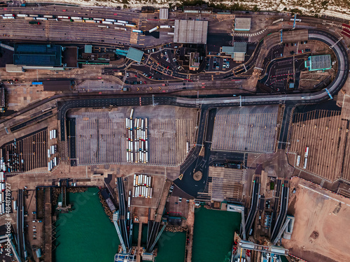 Panoramic view of busie cargo port with hundreds of ships loading export and import goods and thousands of containers in.