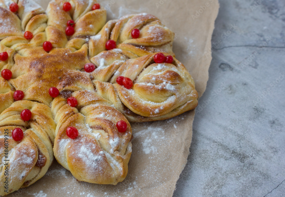appetizing baked star cake with red berries and powdered sugar close-up on rough beige paper appetizing baked star cake with red berries and powdered sugar close-up on rough beige paper
