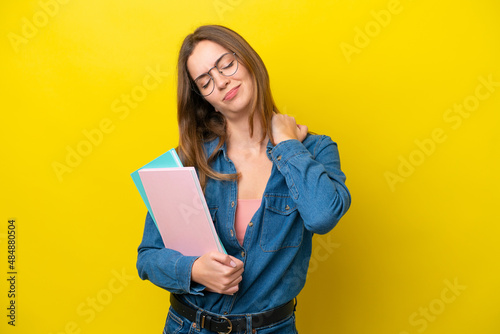 Young student caucasian woman isolated on yellow background suffering from pain in shoulder for having made an effort