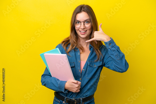 Young student caucasian woman isolated on yellow background making phone gesture. Call me back sign