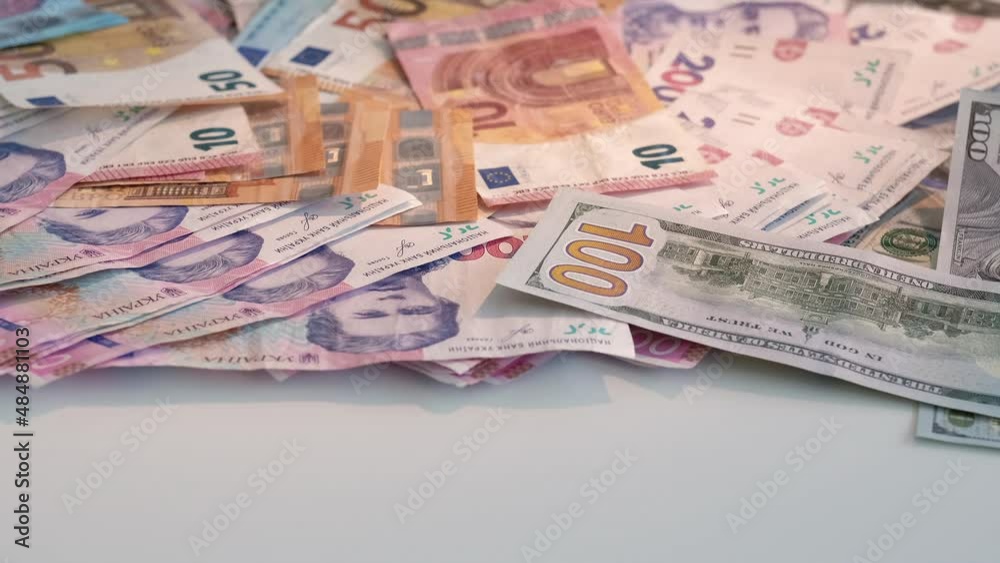 International currency. Monetary policy. Global trade. Colorful Euro us dollar uah ukrainian hryvnia bill paper banknotes cash money pile isolated on white background. International currency. Monetary policy. Global trade. Colorful Euro us dollar uah ukrainian hryvnia bill paper banknotes cash money pile isolated on white background.