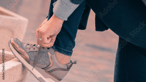 Manos de chica atando las zapatillas de deporte photo