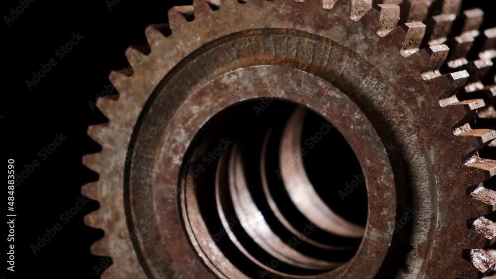 Rotation of a metal gear part of an old mechanism covered with dust on a black background close-up Rotation of a metal gear part of an old mechanism covered with dust on a black background close-up